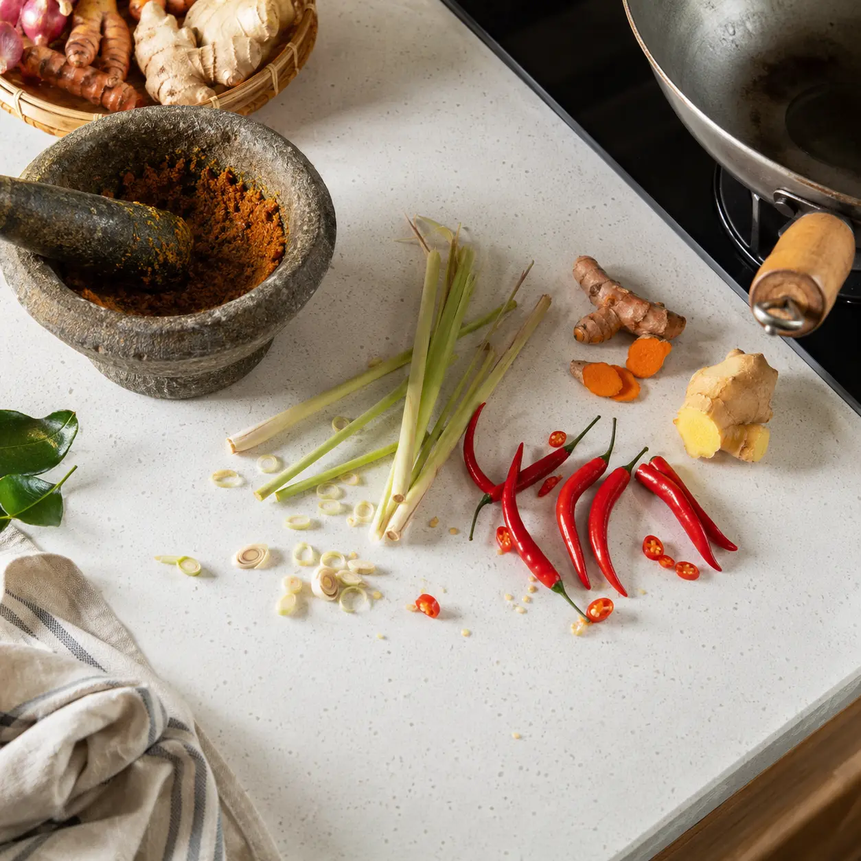 Malaysian cooking scene with turmeric and spices on a quartz stone countertop
