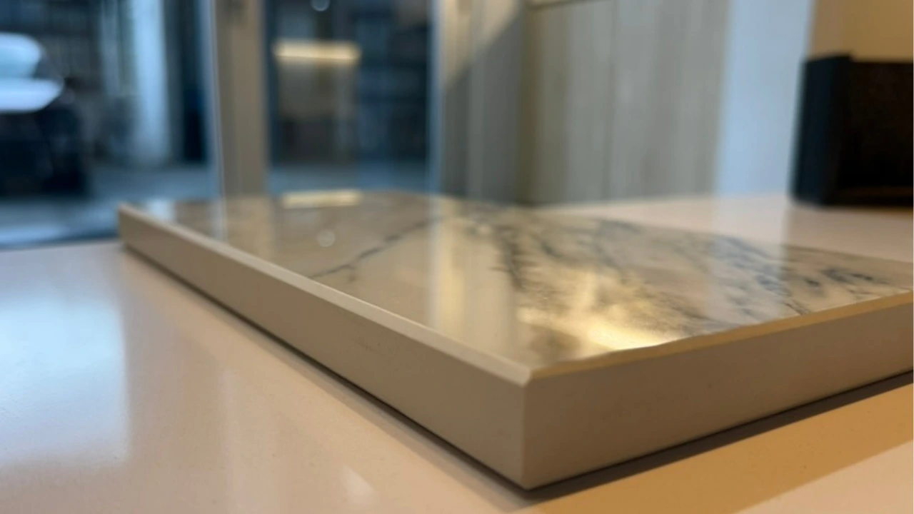 Cross-section of porcelain slab showing 1mm printed marble pattern on surface with plain white body beneath