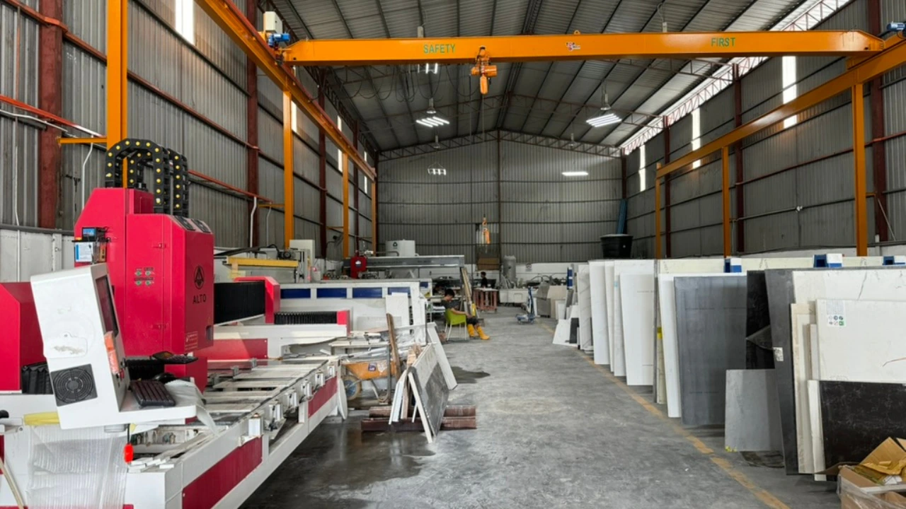 CNC machine milling a precise rectangular sink cutout in a quartz stone countertop piece
