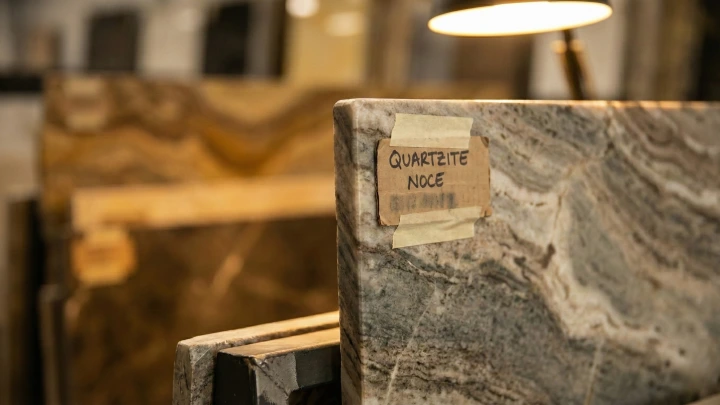 Close-up of a natural stone slab in a showroom with a handwritten commercial name label, illustrating how stones receive trade names rather than geological classifications Close-up of a natural stone slab in a showroom with a handwritten commercial name label, illustrating how stones receive trade names rather than geological classifications