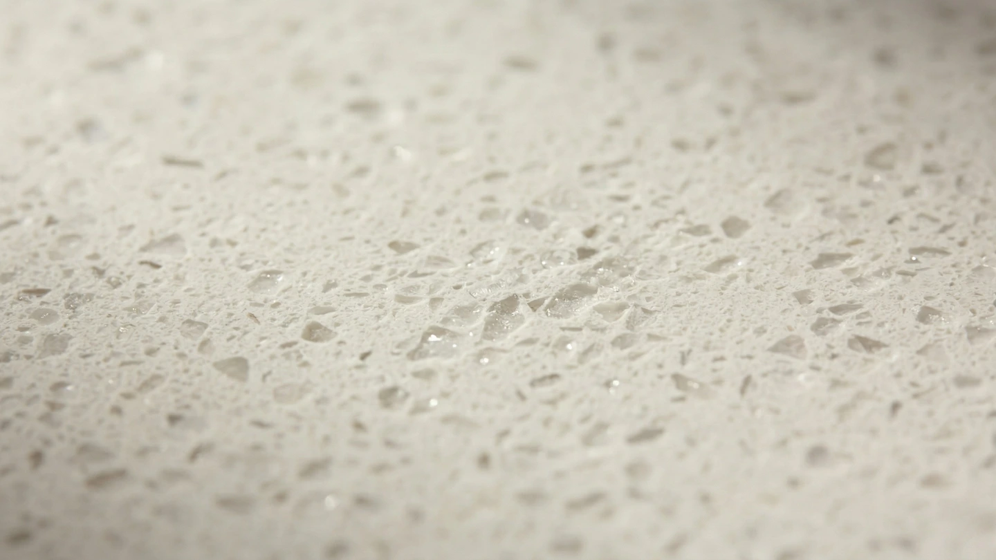 Close-up of engineered quartz countertop surface showing uniform crystal texture and polished finish in a Malaysian kitchen Close-up of engineered quartz countertop surface showing uniform crystal texture and polished finish in a Malaysian kitchen
