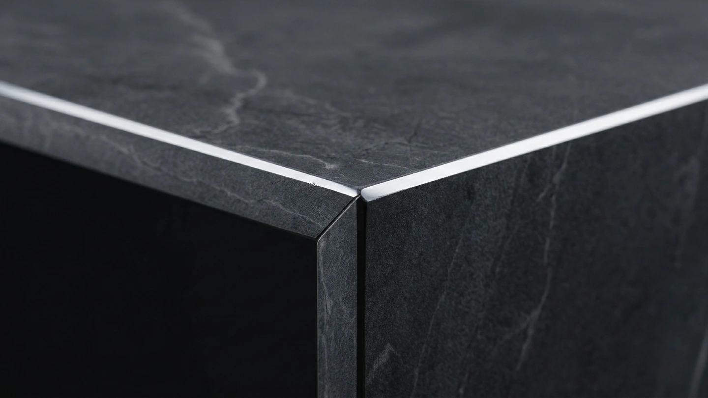 Close-up of a polished mitre edge joint on a sintered stone kitchen countertop showing fabrication precision and finish quality Close-up of a polished mitre edge joint on a sintered stone kitchen countertop showing fabrication precision and finish quality